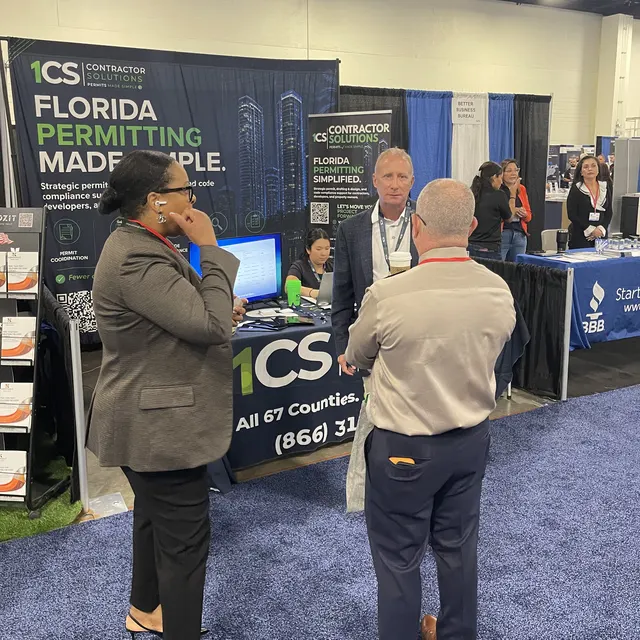 Attendees stopping at the 1CS booth to talk with our team